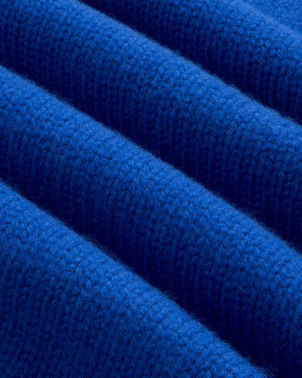 Bright blue Cashmere Crewneck Sweater folded in even, diagonal pleats.