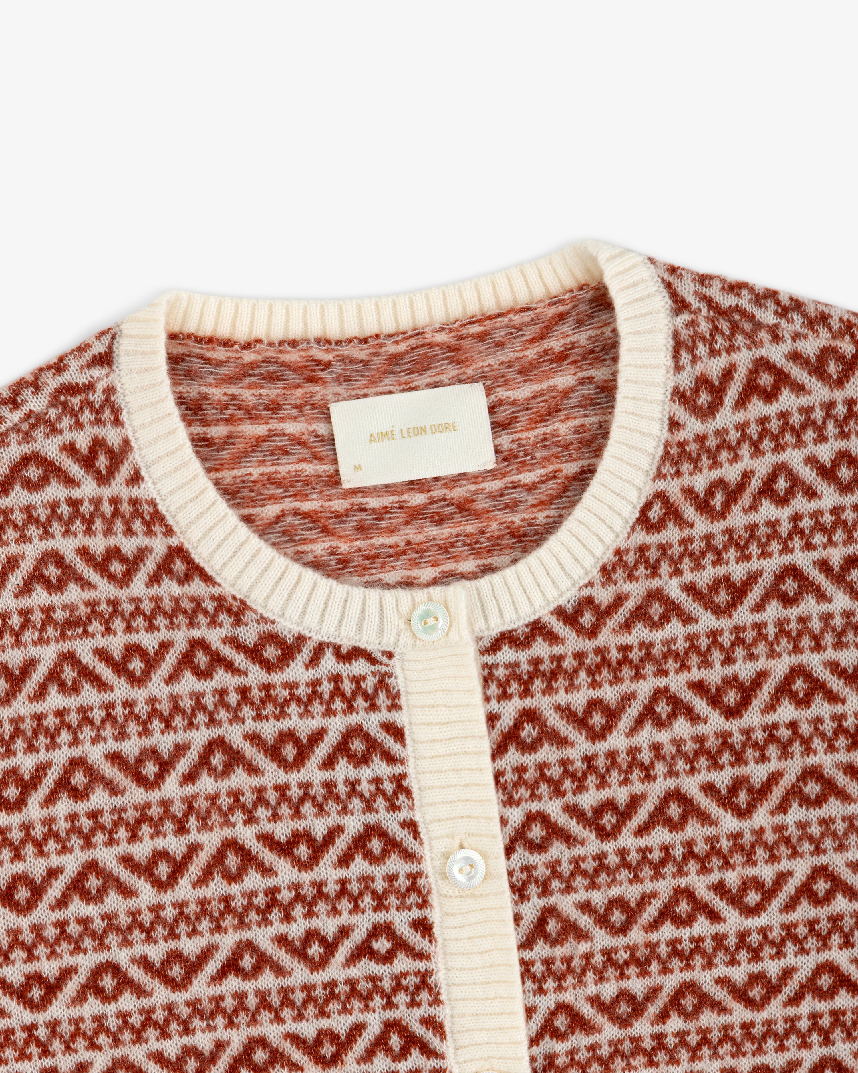 Wool Cashmere Jacquard Cardigan with a rust and cream geometric pattern and a cream-colored ribbed collar.
