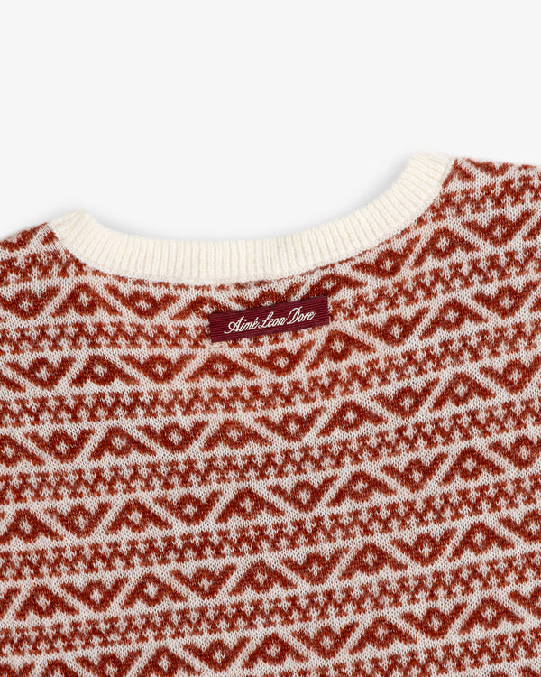 Close-up of a Wool Cashmere Jacquard Shell sleeveless knit sweater in a red and cream geometric pattern with a neck label.