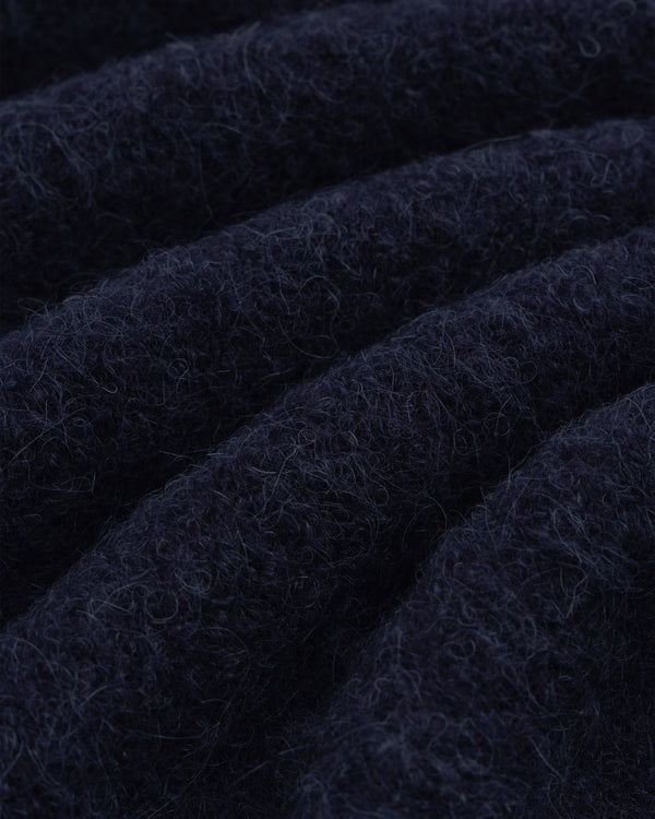 Close-up of dark blue, textured alpaca wool from our Quarter Zip Sweater, showing visible fibers and soft folds.