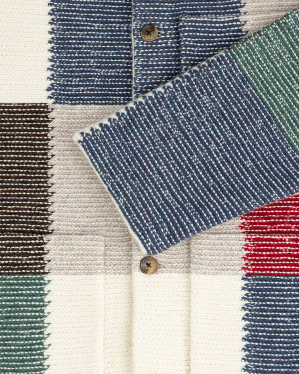 Patchwork Knit Chore Jacket featuring a patchwork pattern of blue, cream, green, brown, and red squares with two buttons.