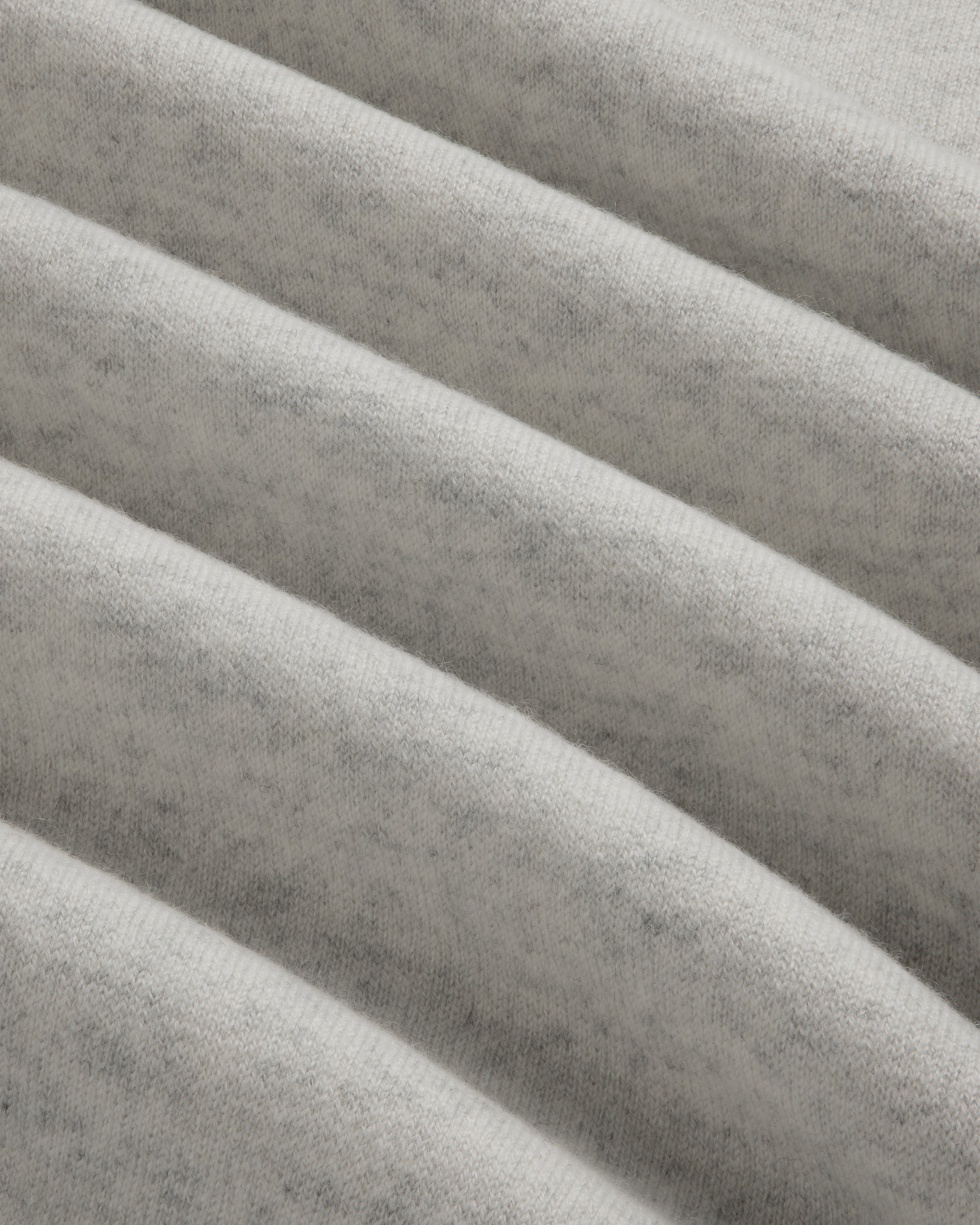 Close-up of Pavilion Cashmere Crewneck Sweatshirt in light gray, showing soft ribbed fabric and horizontal ridges.