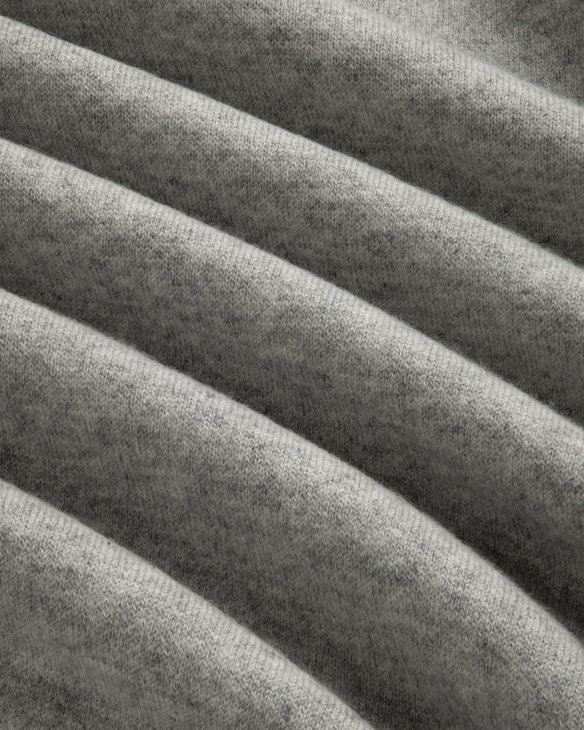 Closeup of Pavilion Cashmere Crewneck Sweatshirt in soft gray ribbed fabric with horizontal folds and texture.