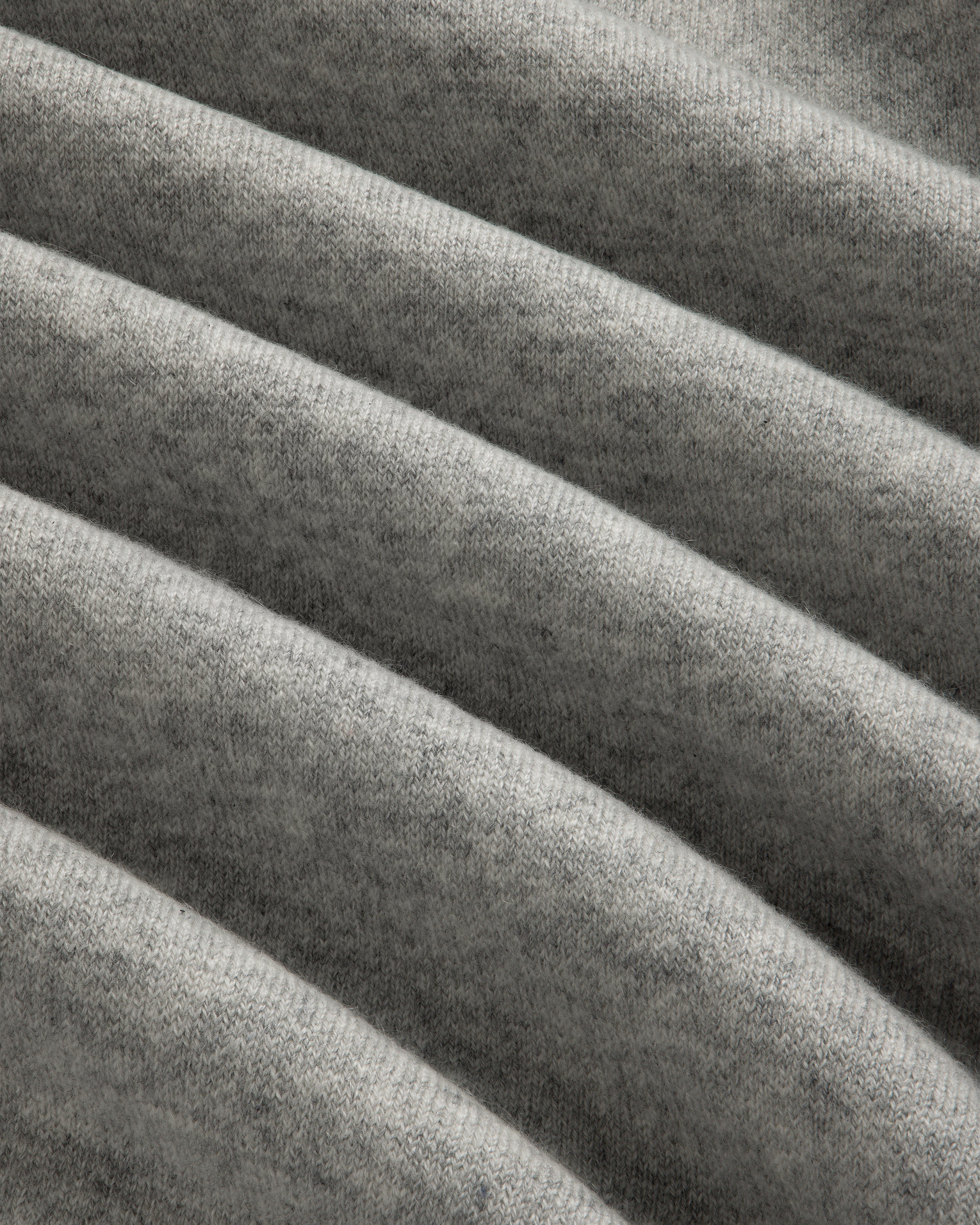 Closeup of Pavilion Cashmere Crewneck Sweatshirt in soft gray ribbed fabric with horizontal folds and texture.