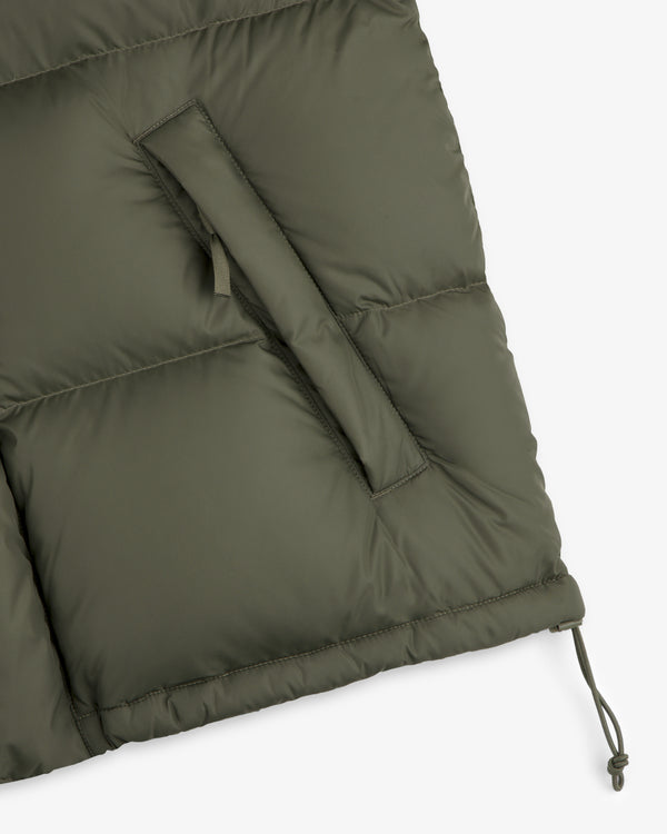 Close-up of the ALD / The North Face Baltoro Jacket in olive with a zippered pocket and adjustable drawstring hem.