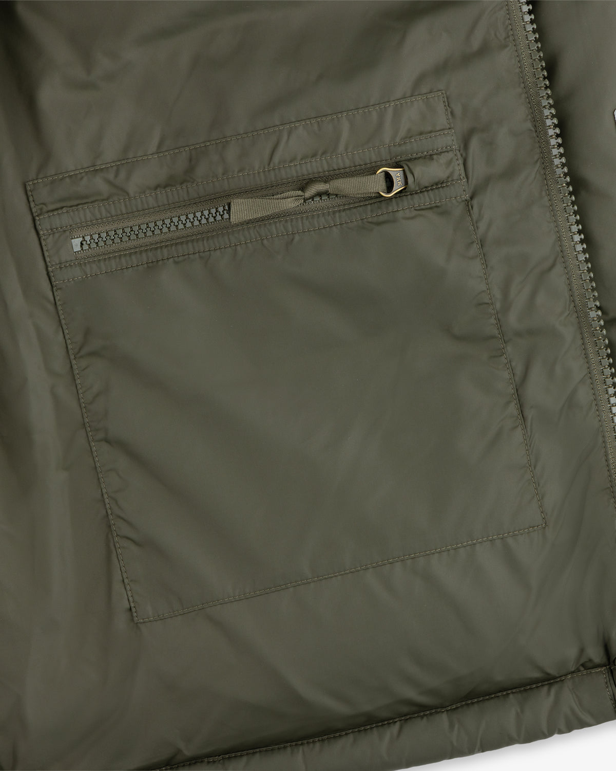 Close-up of an ALD / The North Face Baltoro Jacket pocket with a horizontal zipper and visible stitching.