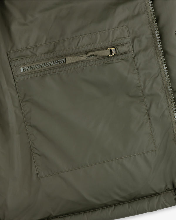 Close-up of an ALD / The North Face Baltoro Jacket pocket with a horizontal zipper and visible stitching.