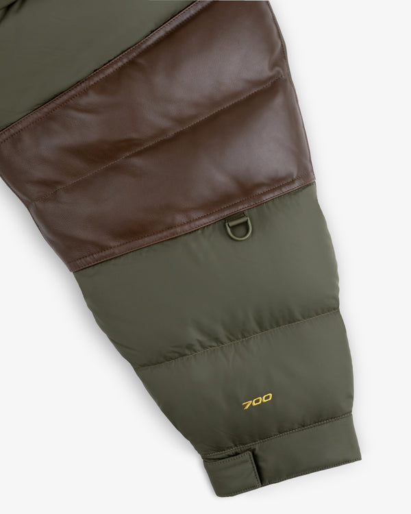 Close-up of ALD / The North Face Baltoro Jacket sleeve, green and brown with yellow “700” embroidered near cuff.