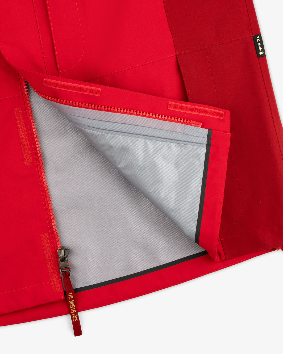 ALD/The North Face GORE-TEX 2000 Mountain Jacket in red, partially unzipped to reveal gray lining and seam details.