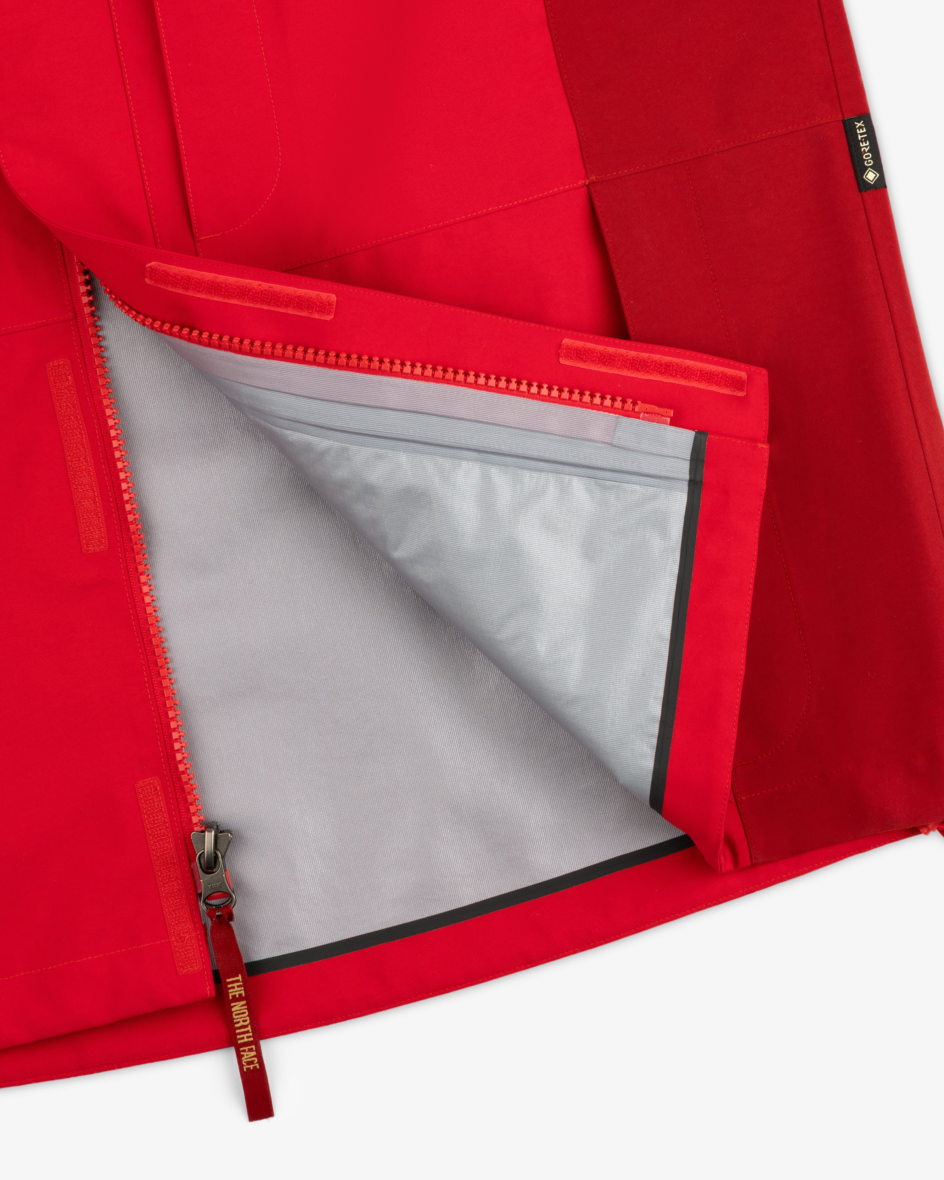 ALD/The North Face GORE-TEX 2000 Mountain Jacket in red, partially unzipped to reveal gray lining and seam details.