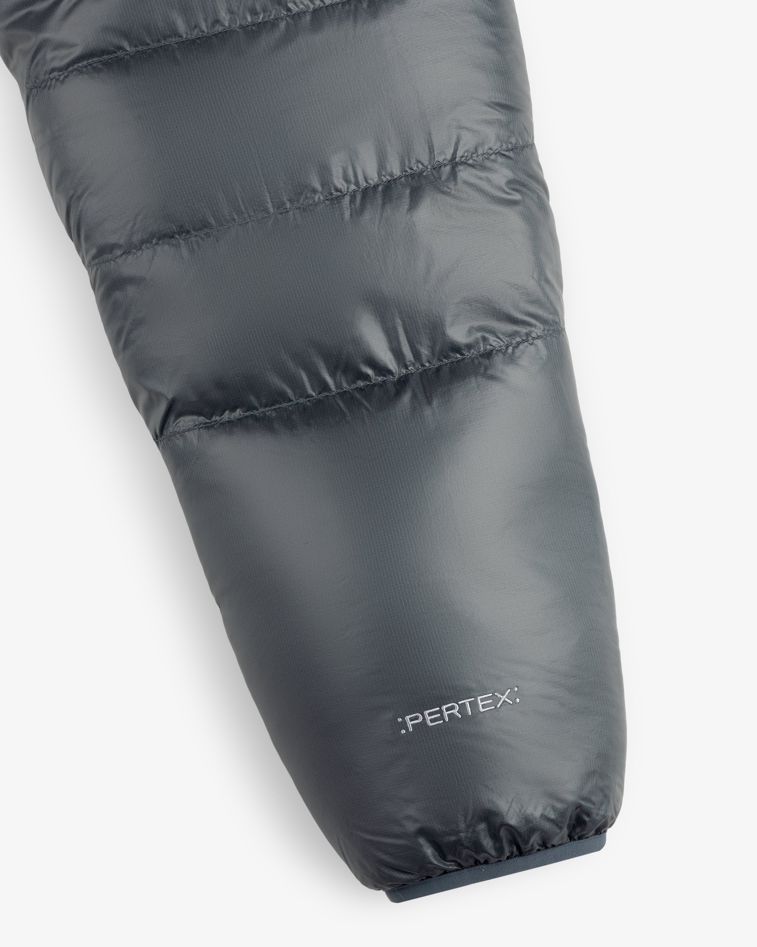 Close-up of ALD/The North Face Reversible Pertex® Nuptse Jacket sleeve with branding on white background.