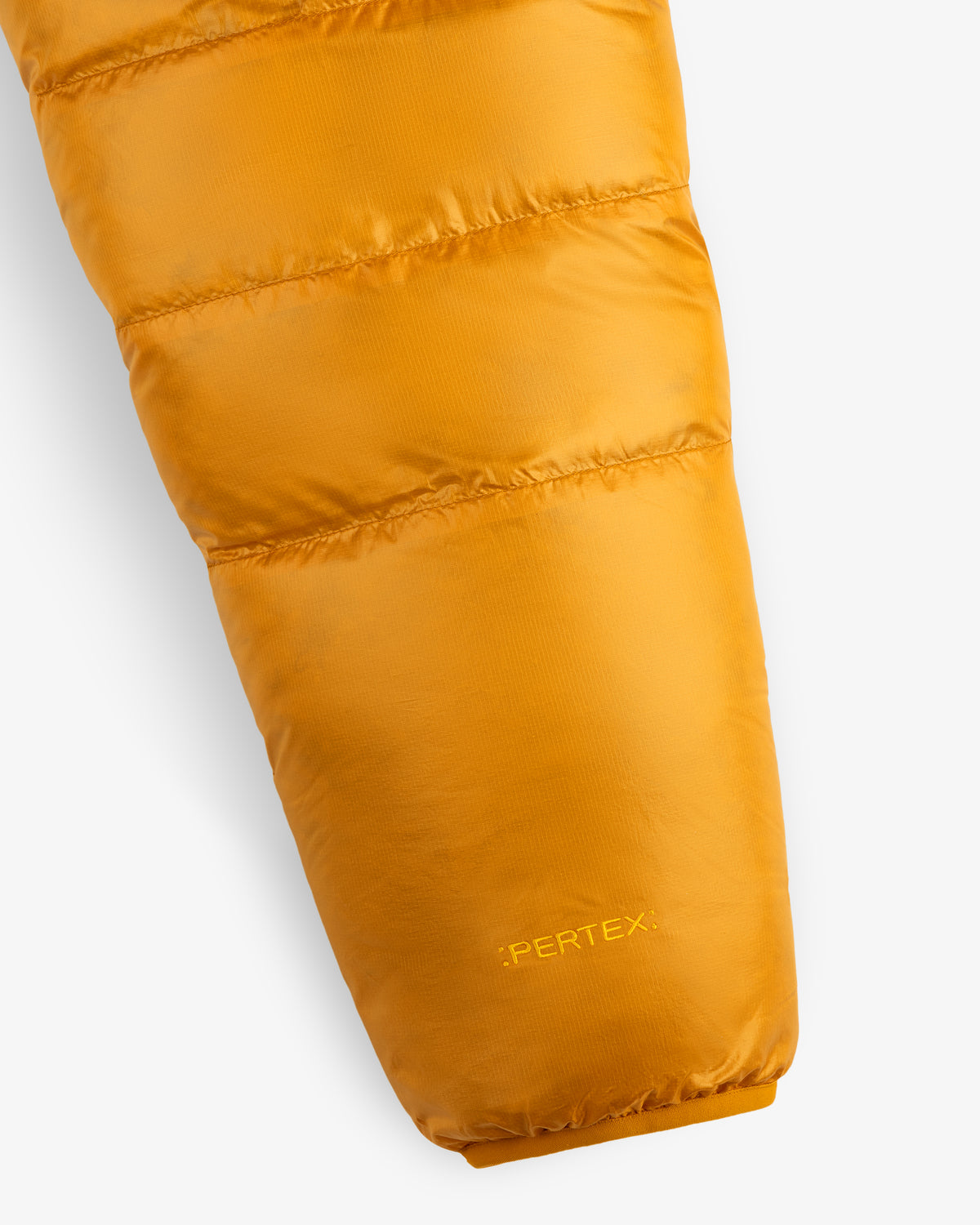 Close-up of ALD/The North Face Reversible Pertex® Nuptse Jacket sleeve with logo on cuff, white background.