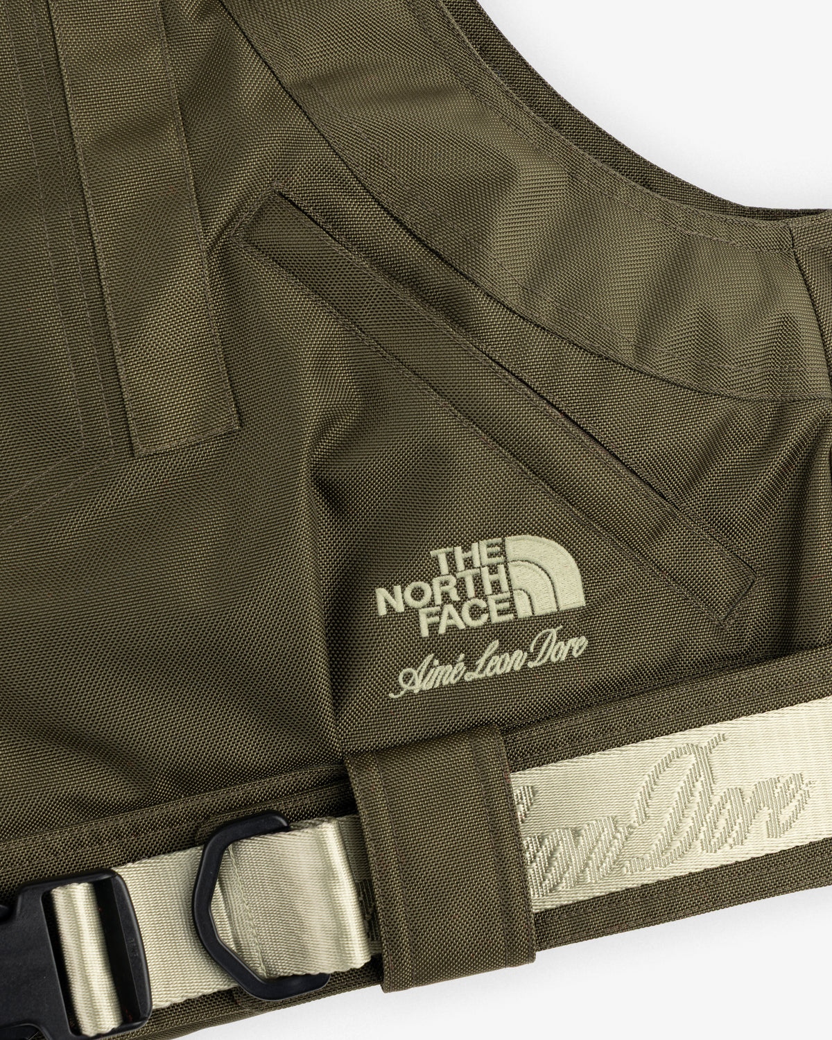 Close-up of the ALD / The North Face Ballistic Tech Vest in olive green, logos embroidered on the chest.