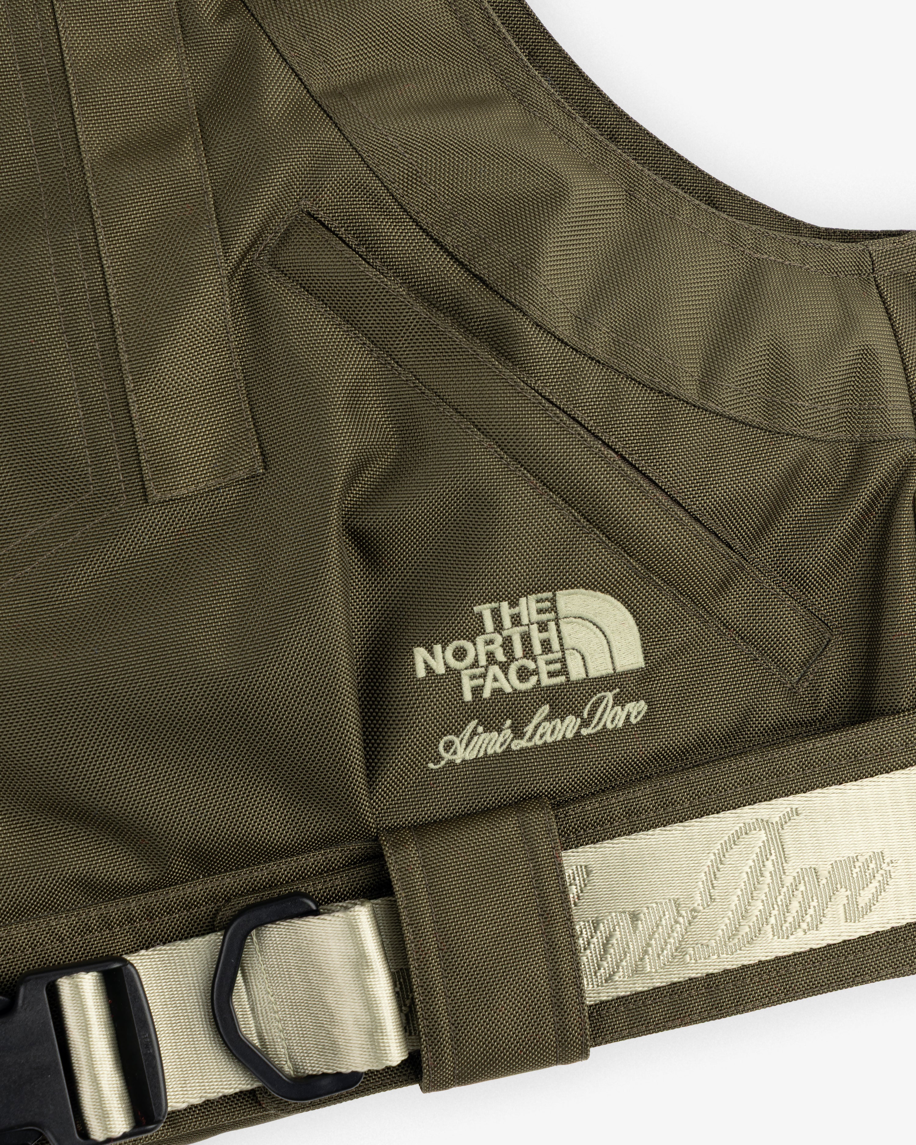 Close-up of the ALD / The North Face Ballistic Tech Vest in olive green, logos embroidered on the chest.