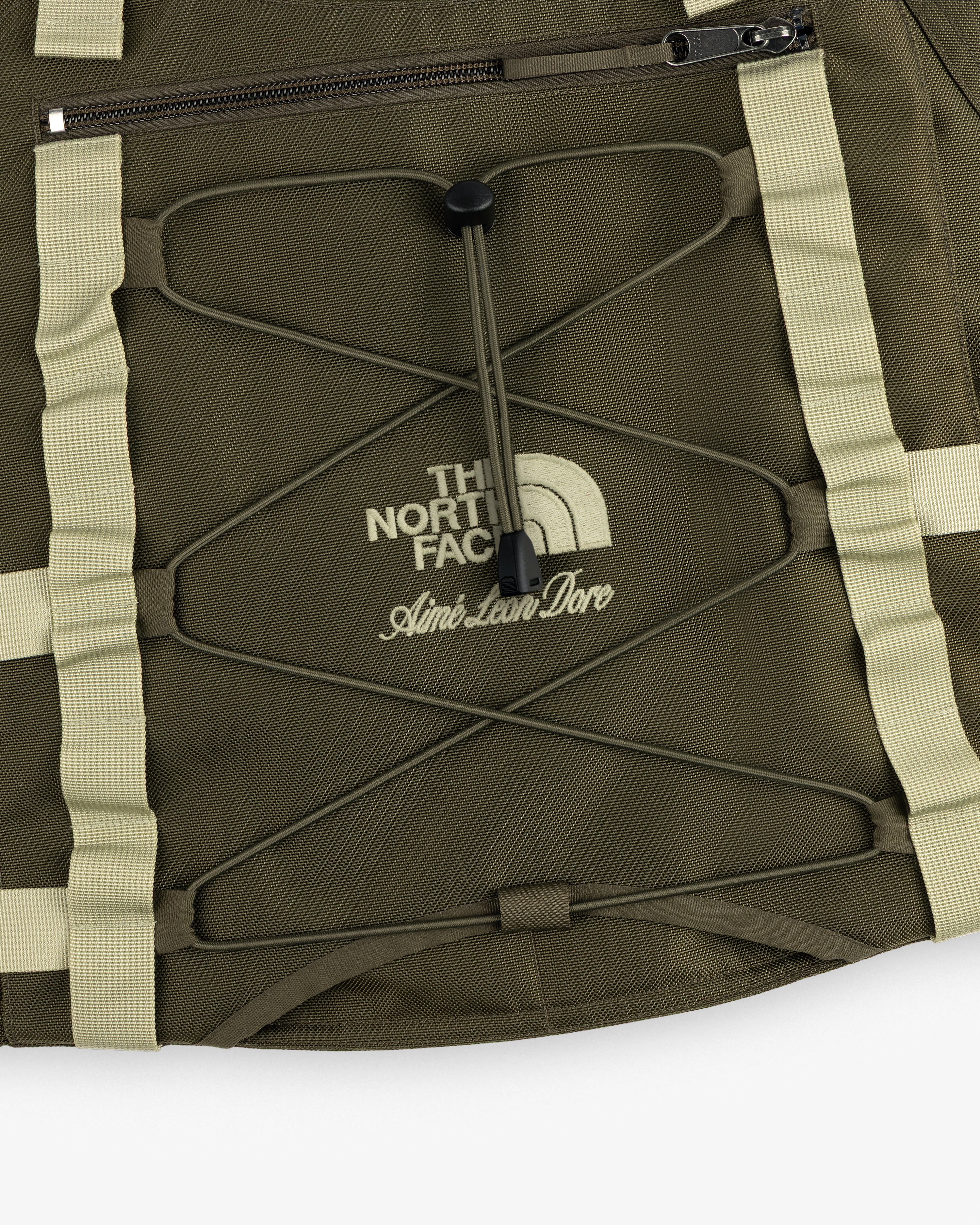 Close-up of an olive green ALD / The North Face Ballistic Tech Vest with cream accents and visible logo.