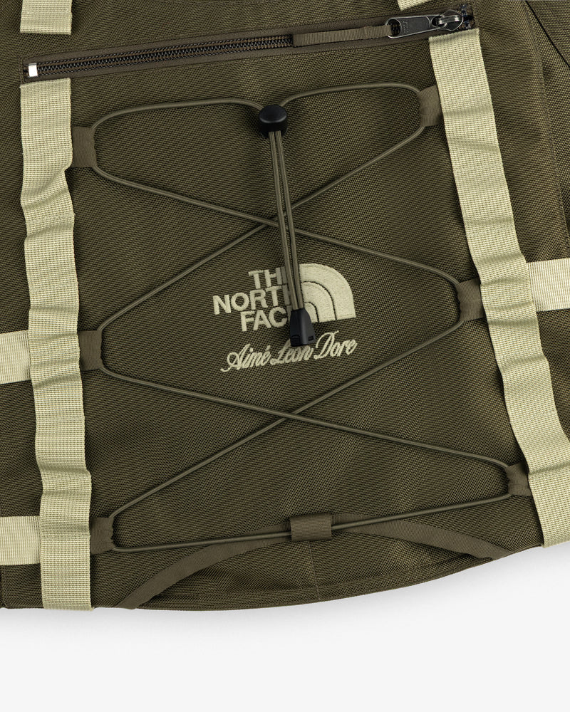Close-up of an olive green ALD / The North Face Ballistic Tech Vest with cream accents and visible logo.