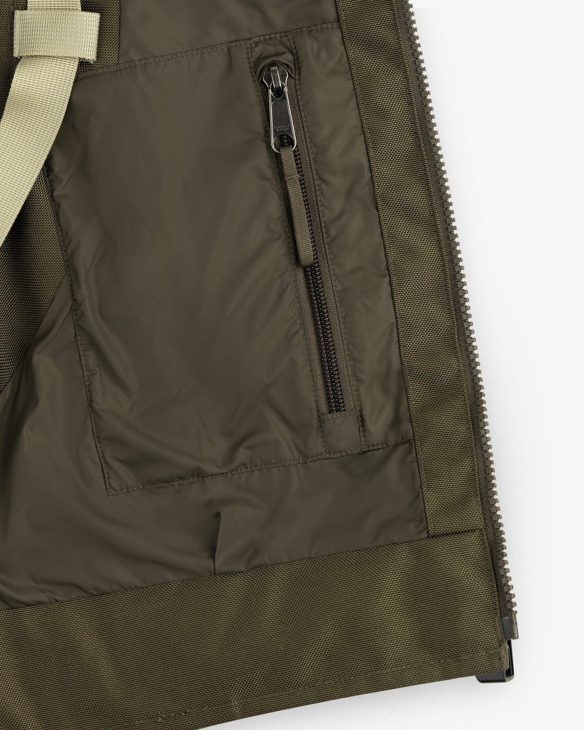 Close-up of the ALD/The North Face Ballistic Tech Vest pocket with black zipper and beige strap detail.