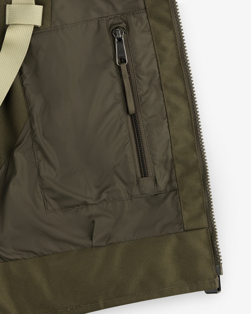 Close-up of the ALD/The North Face Ballistic Tech Vest pocket with black zipper and beige strap detail.