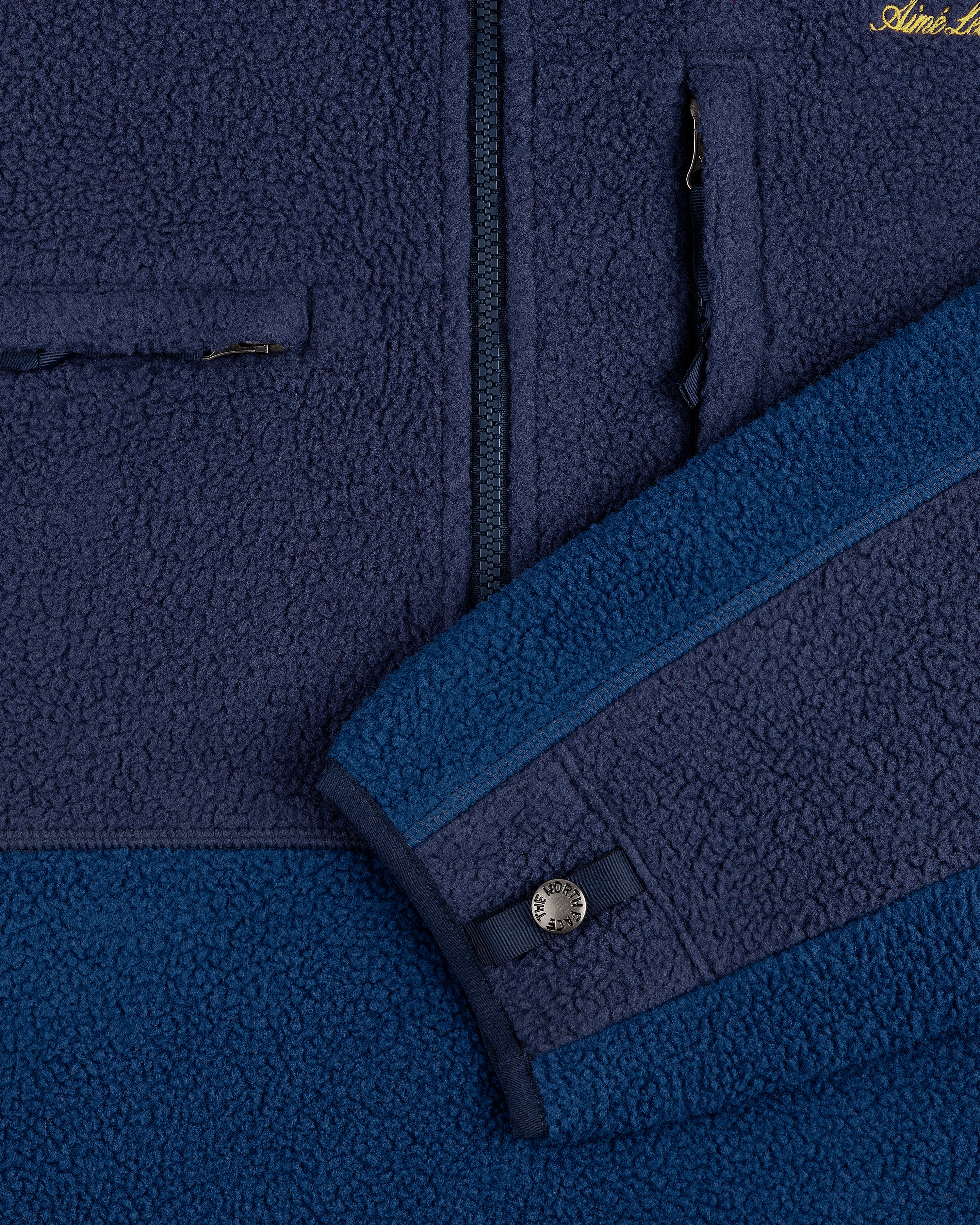 Close-up of the ALD/The North Face ’95 Denali Half-Zip Fleece Pullover in blue with a chest zip pocket and sleeve snap.