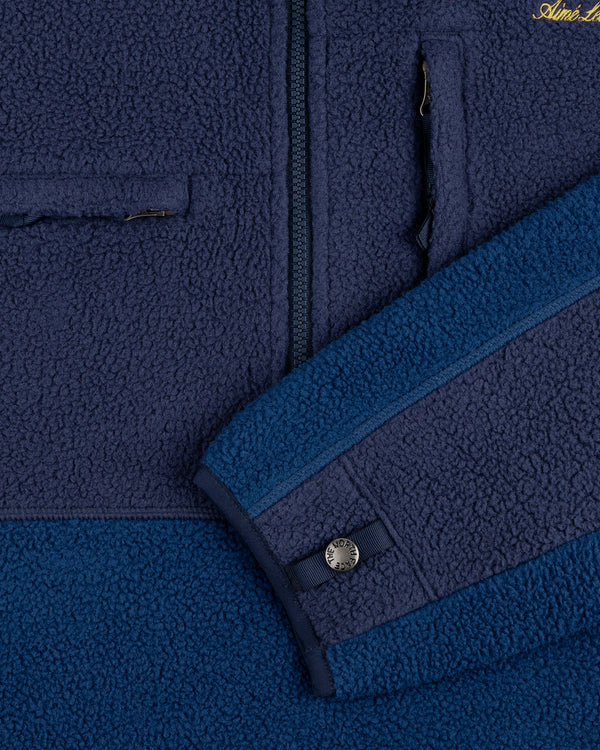 Close-up of the ALD/The North Face ’95 Denali Half-Zip Fleece Pullover in blue with a chest zip pocket and sleeve snap.