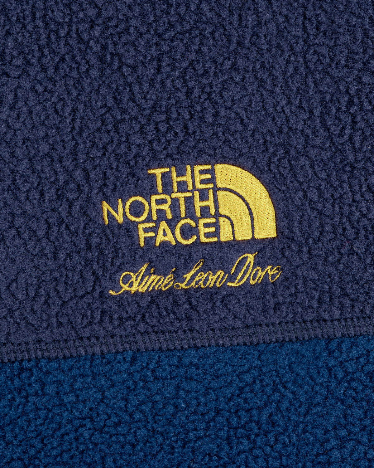 Yellow ALD and The North Face logos on navy ’95 Denali Half-Zip Fleece Pullover’s textured fabric.