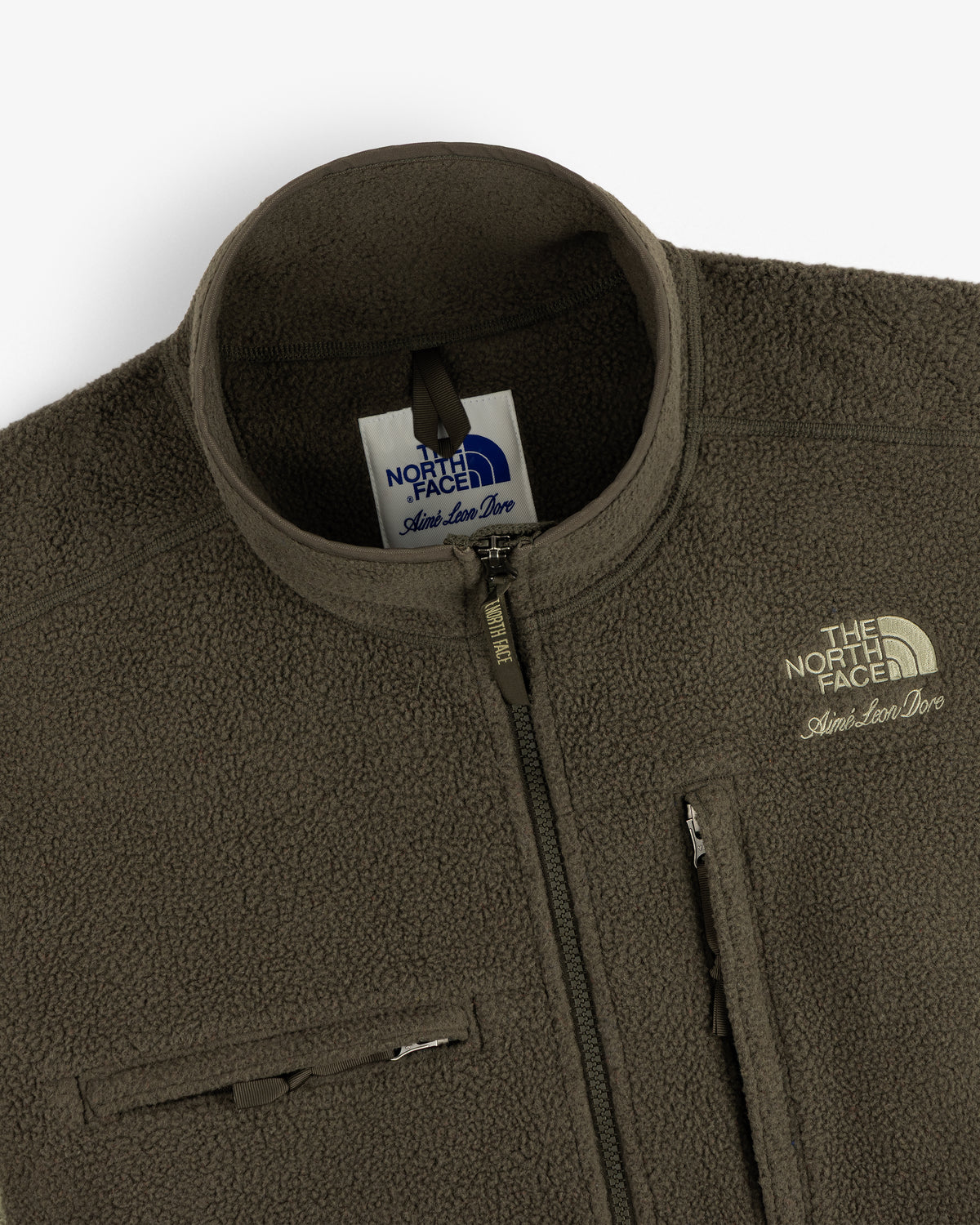 Close-up of the olive green ALD/The North Face ’95 Denali Half-Zip Fleece Pullover with two chest zip pockets and logo.
