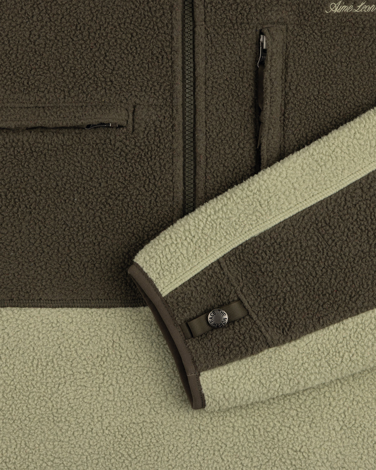 Close-up of ALD / The North Face ’95 Denali Half-Zip in two greens, with zip pockets and snap cuff detail.