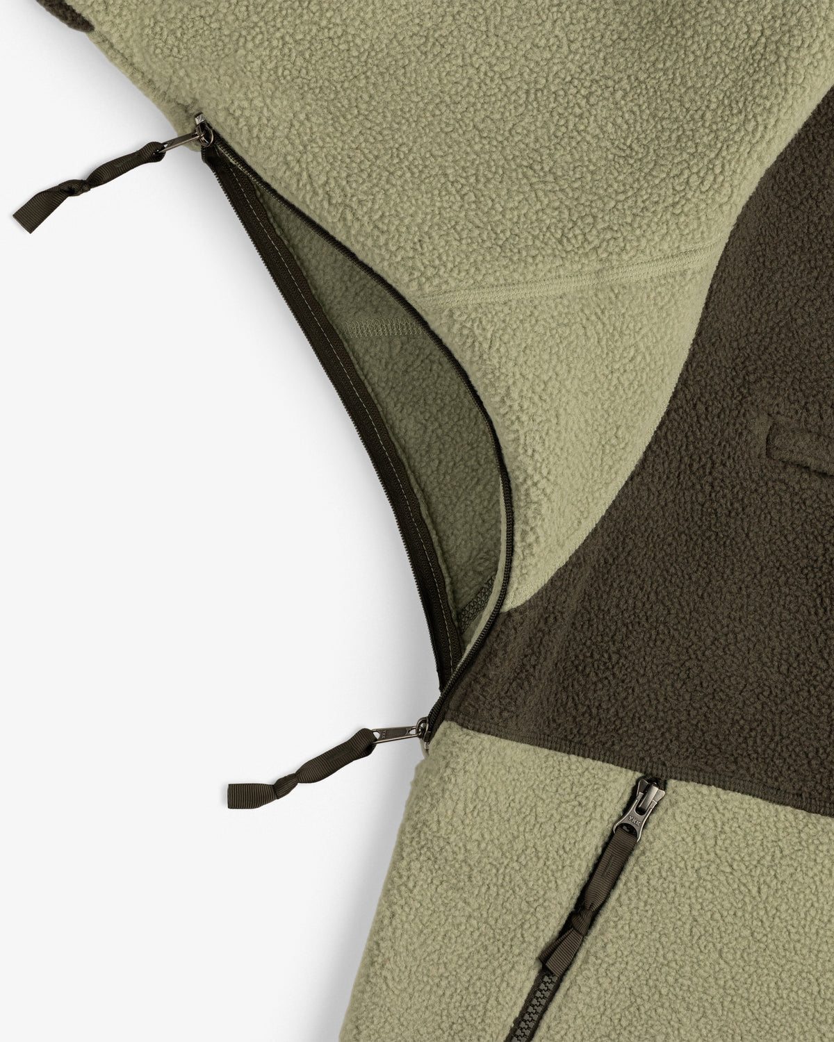 Close-up of ALD/The North Face ’95 Denali Half-Zip Fleece Pullover, green/brown, with two zippers and textured fabric.