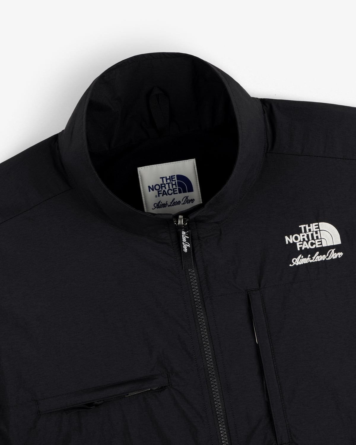 Close-up of a black ALD / The North Face Nylon Denali Jacket, showing zipper, chest pocket, and label.
