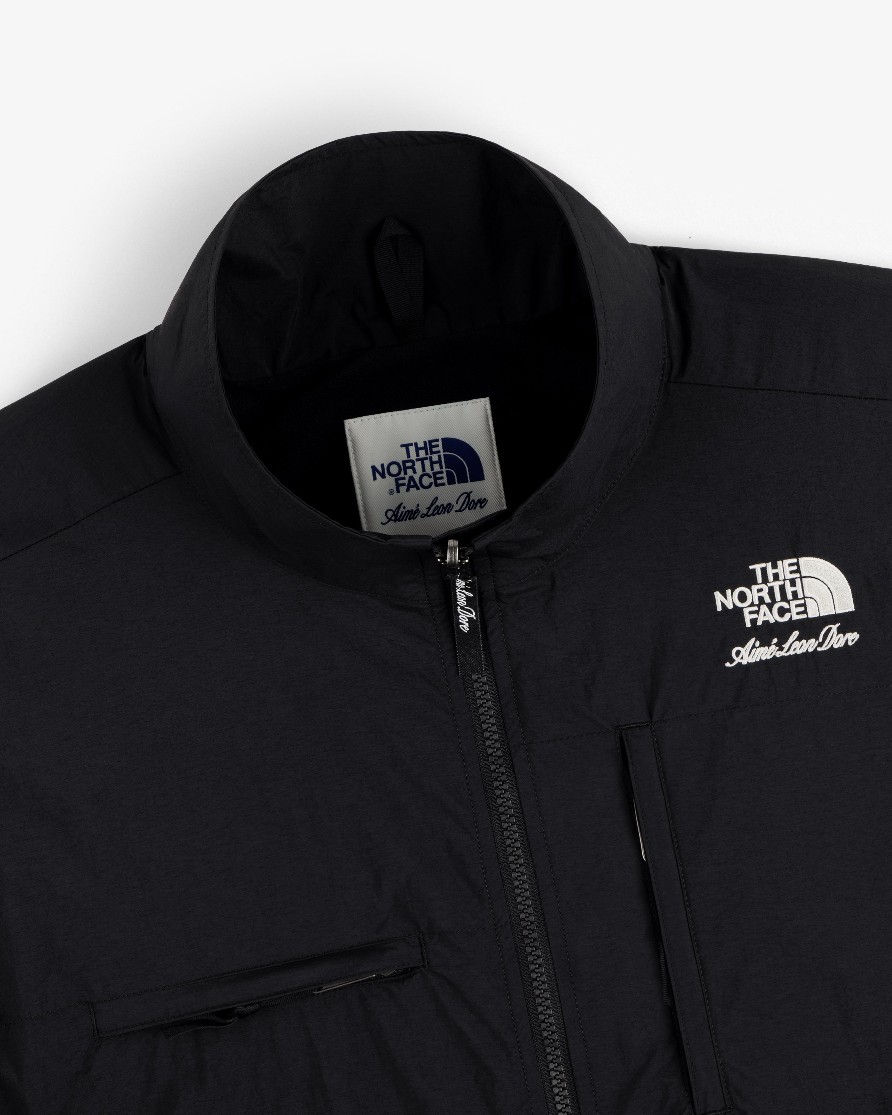 Close-up of a black ALD / The North Face Nylon Denali Jacket, showing zipper, chest pocket, and label.