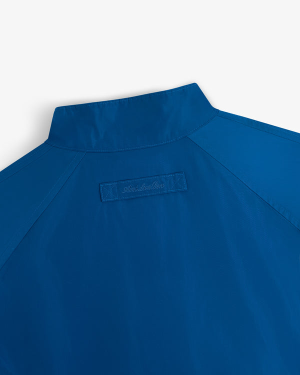Close-up of the Crest Nylon Windbreaker’s back with a short collar and a rectangular stitched patch below it.