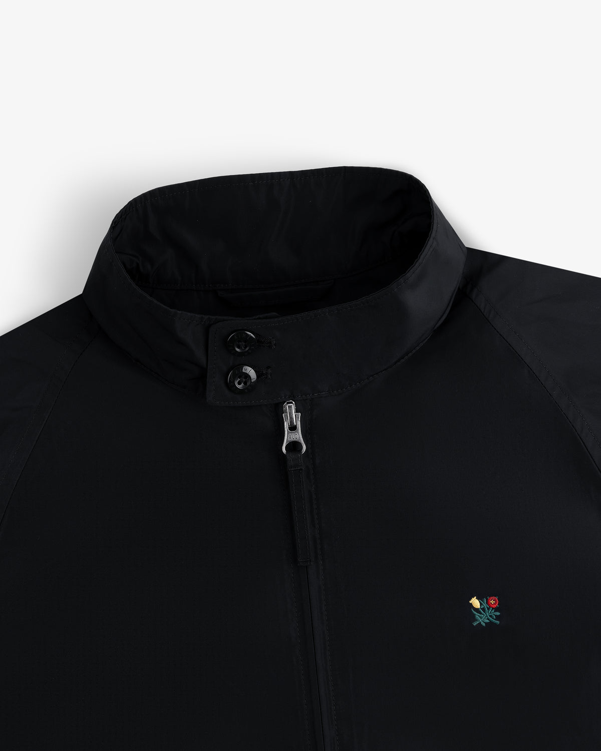 Crest Nylon Windbreaker: black, stand collar, zip/button closure, small floral chest embroidery.