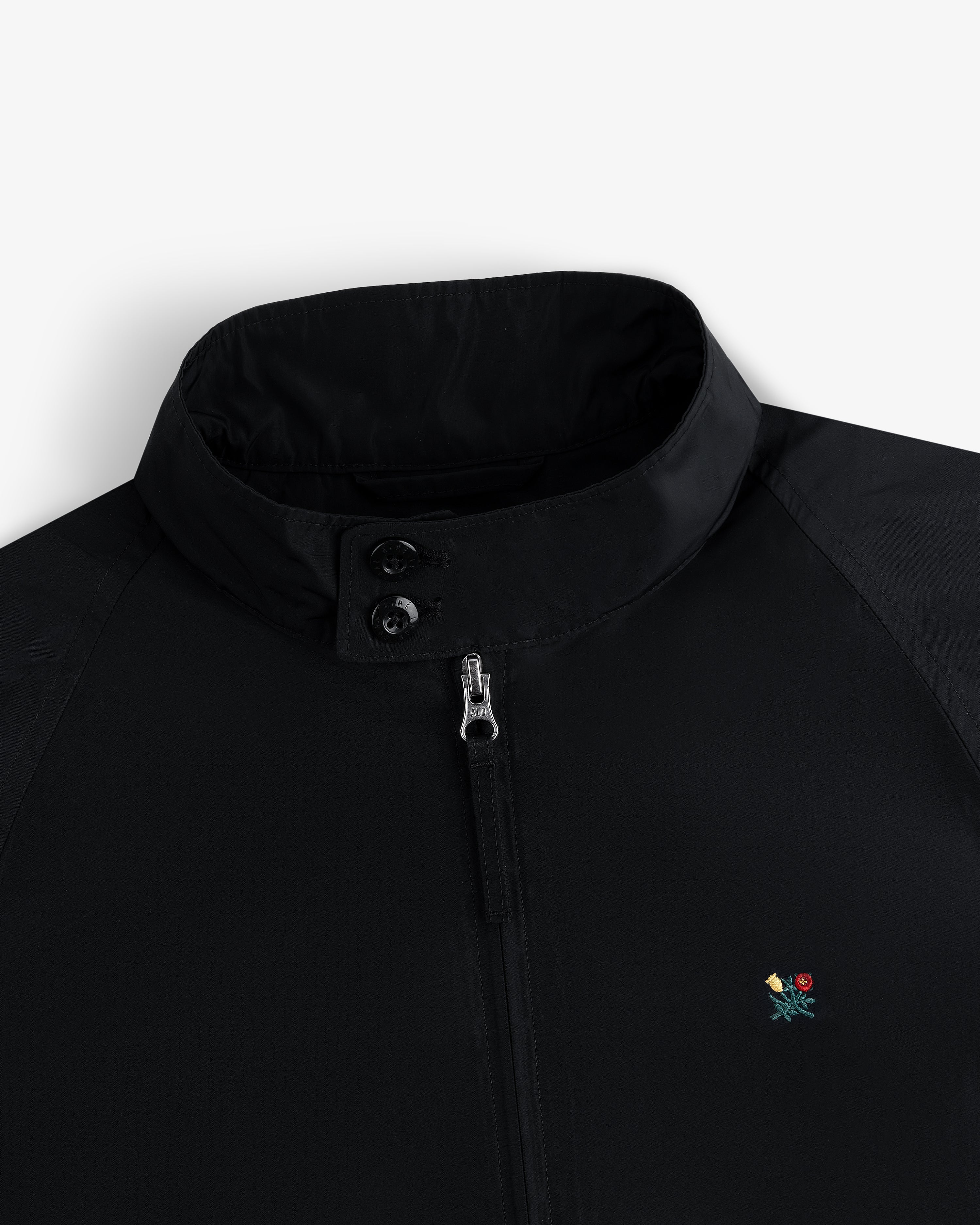 Crest Nylon Windbreaker: black, stand collar, zip/button closure, small floral chest embroidery.