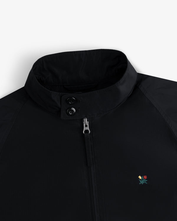 Crest Nylon Windbreaker: black, stand collar, zip/button closure, small floral chest embroidery.