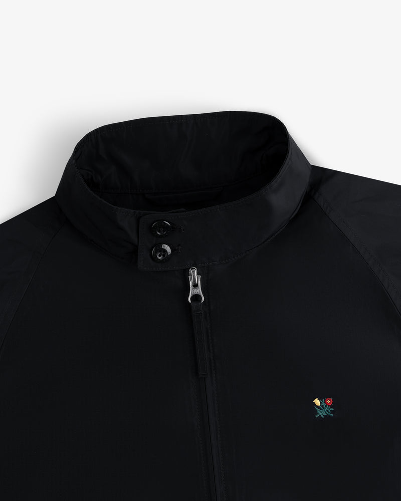 Crest Nylon Windbreaker: black, stand collar, zip/button closure, small floral chest embroidery.