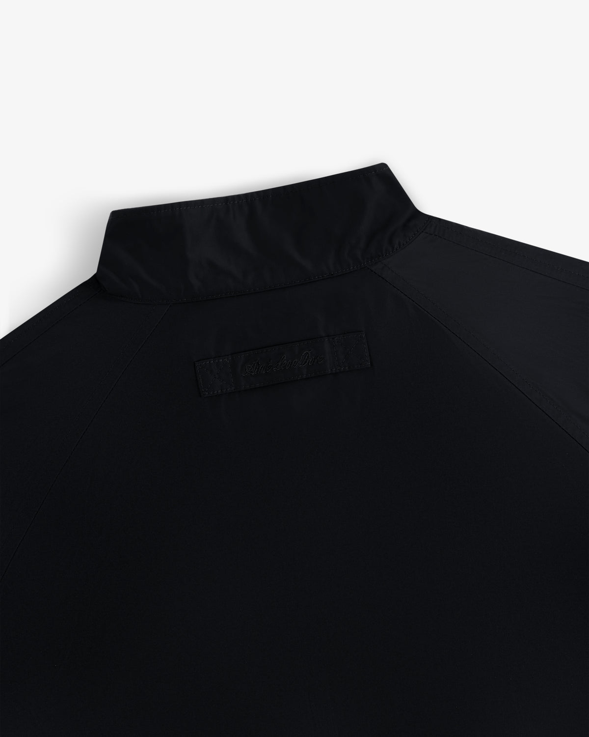 Close-up of the Crest Nylon Windbreaker’s upper back, highlighting its collar and a stitched rectangular patch below.
