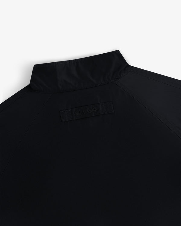 Close-up of the Crest Nylon Windbreaker’s upper back, highlighting its collar and a stitched rectangular patch below.