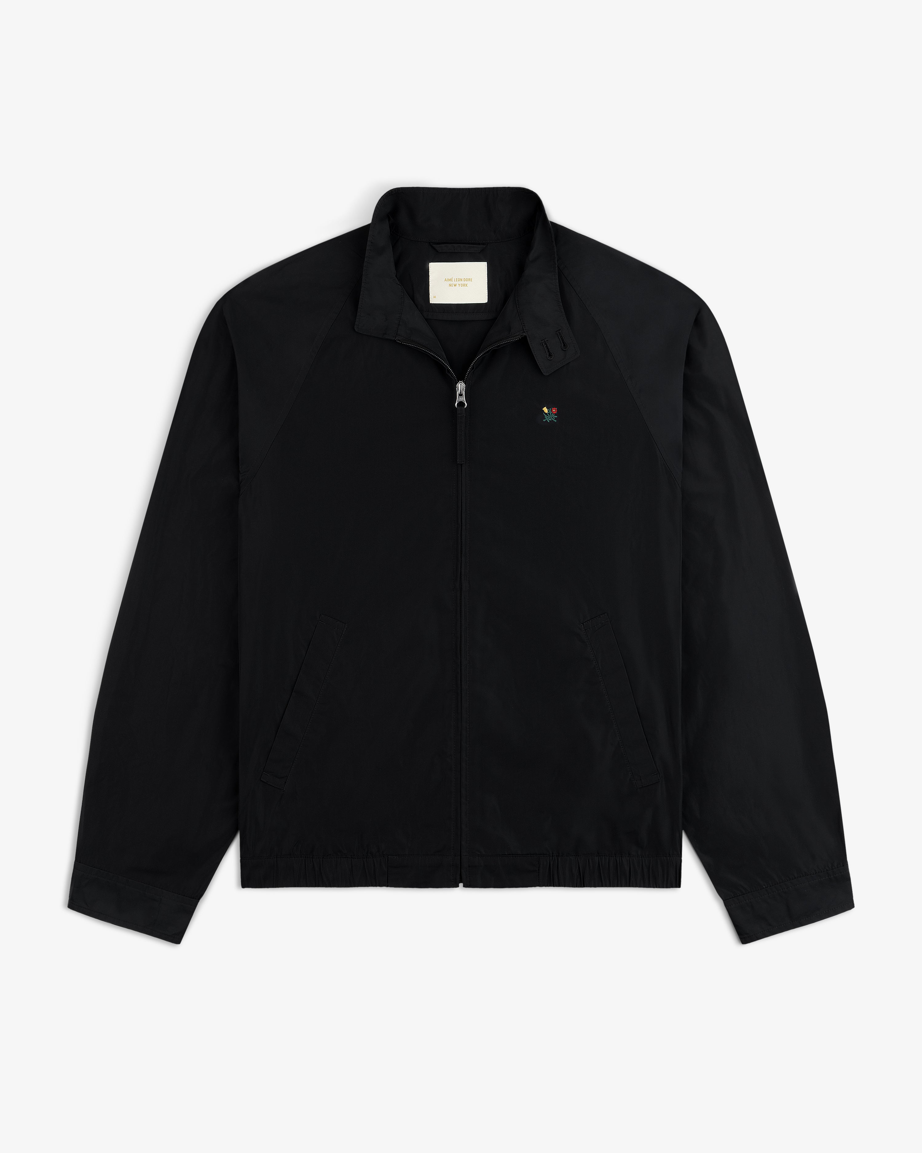 Crest Nylon Windbreaker: Black zip-up with side pockets, chest logo, and a straight collar.