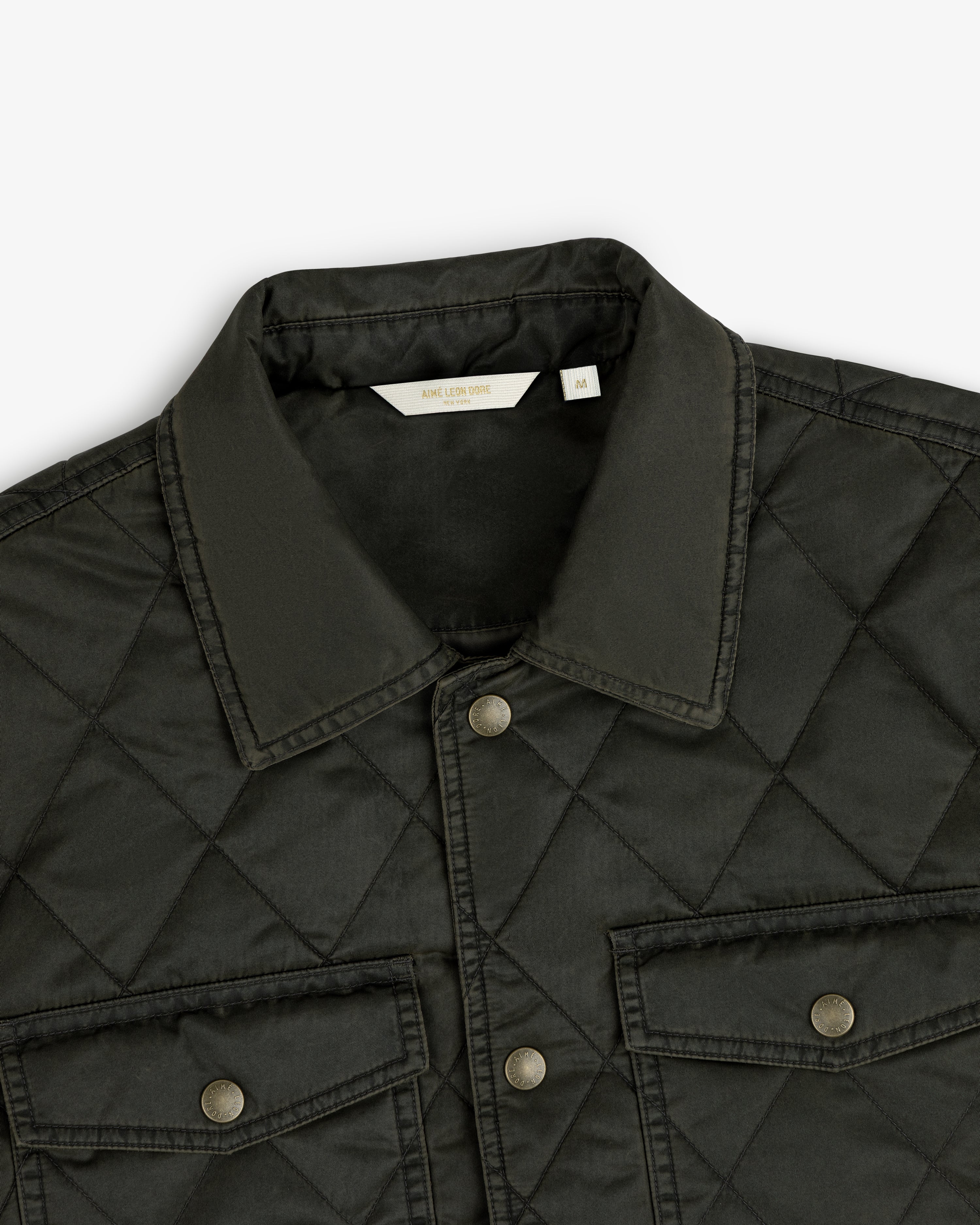 Dark green Quilted Trucker Jacket with a pointed collar, button front, and two buttoned chest pockets.