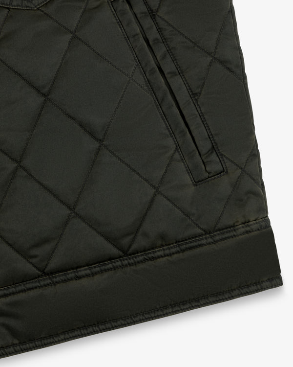 Close-up of a dark olive Quilted Trucker Jacket featuring a side pocket and a wide hem band.