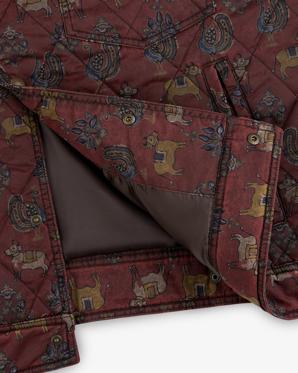Maroon Quilted Trucker Jacket with stylized animal and flower patterns, metal snap buttons, and brown lining.