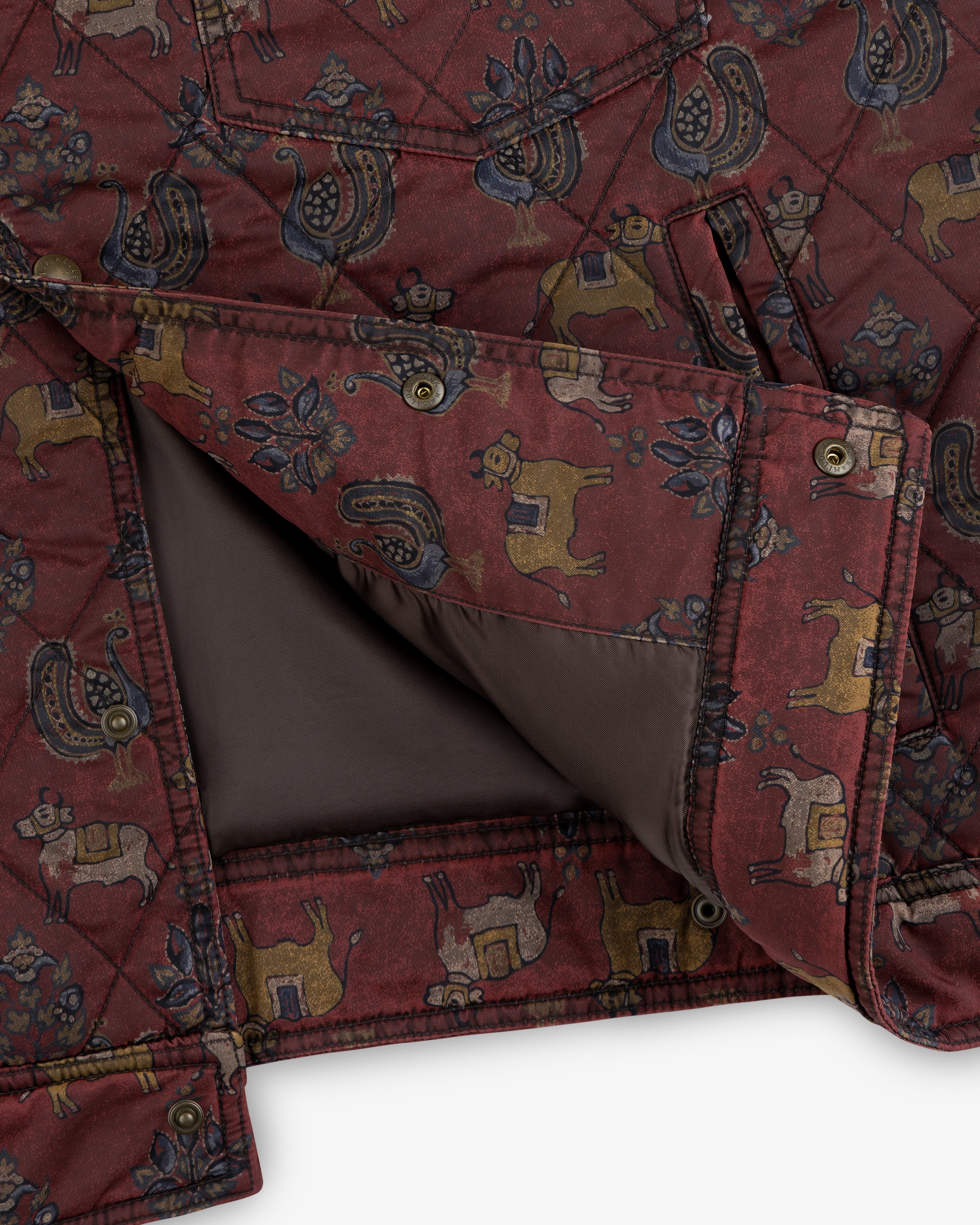 Maroon Quilted Trucker Jacket with stylized animal and flower patterns, metal snap buttons, and brown lining.