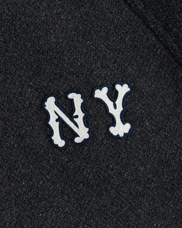 NY Highlanders Wool Varsity Jacket with white, bone-styled NY letters on dark textured fabric.