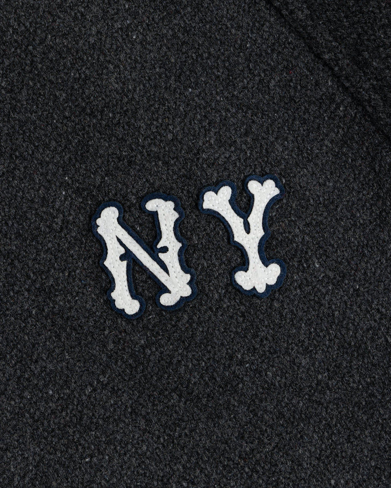 NY Highlanders Wool Varsity Jacket with white, bone-styled NY letters on dark textured fabric.