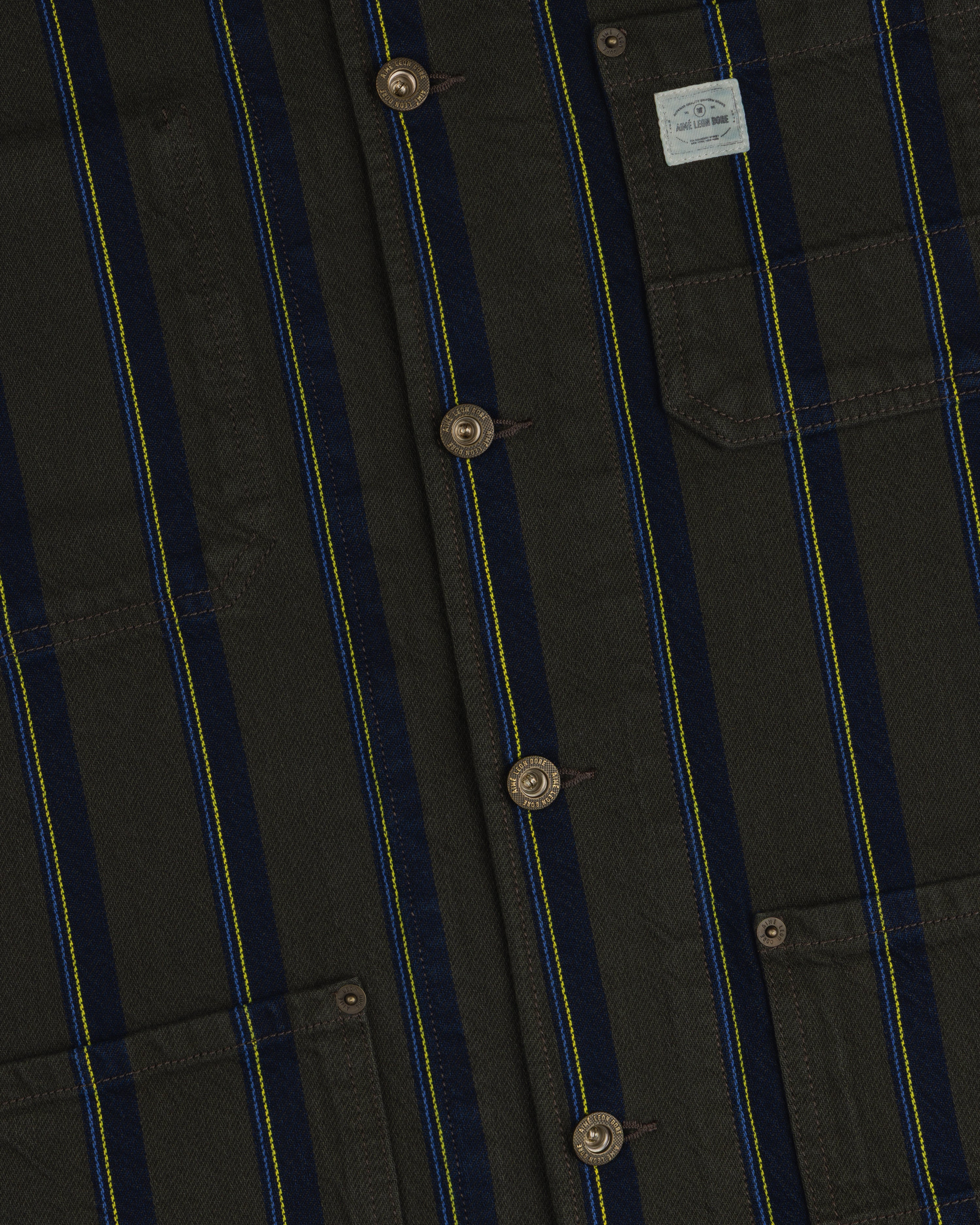 Close-up of a Striped Denim Chore Jacket with buttons, chest pockets, and a small light fabric label.