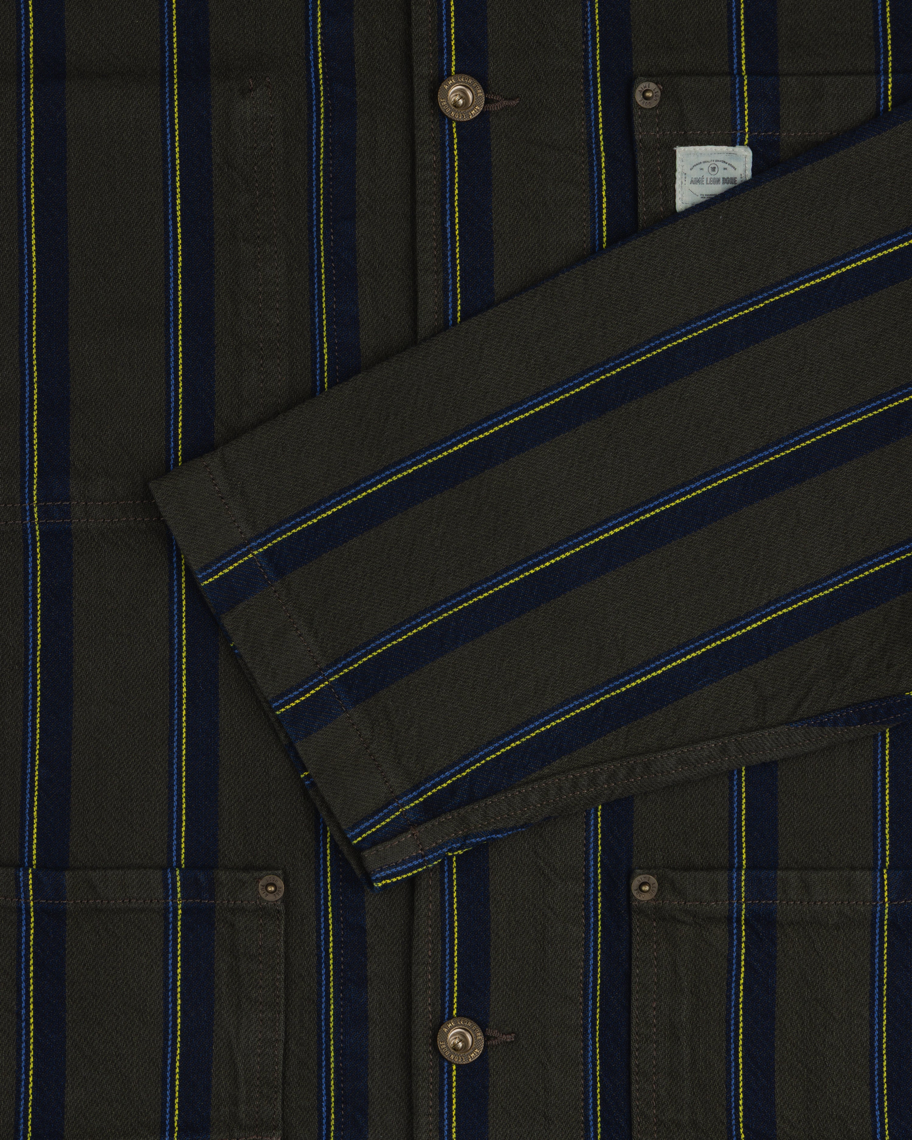 Close-up of the Striped Denim Chore Jacket featuring blue, yellow, and black stripes, buttons, and pockets.