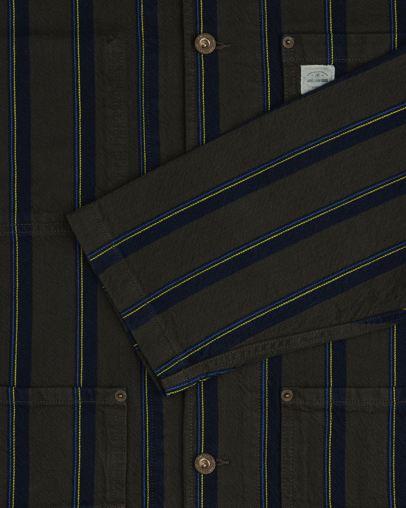 Close-up of the Striped Denim Chore Jacket featuring blue, yellow, and black stripes, buttons, and pockets.