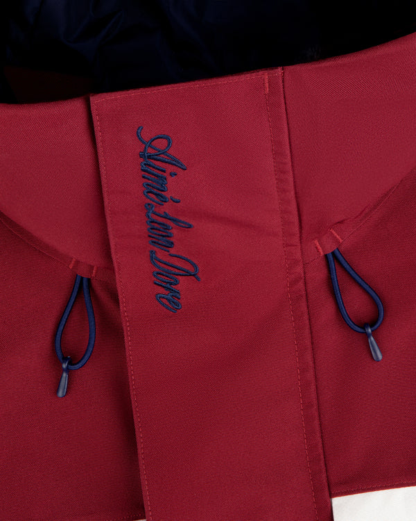 Close-up of red GORE-TEX Striped Sailing Jacket with Aimé Leon Dore blue embroidery and two blue drawstrings.