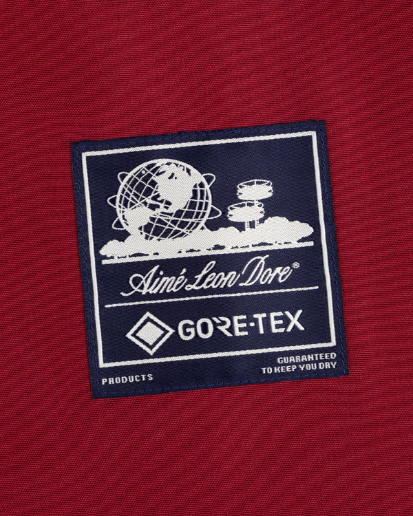 GORE-TEX Striped Sailing Jacket with Aimé Leon Dore patch on red, globe motif, and dryness-guaranteed text.