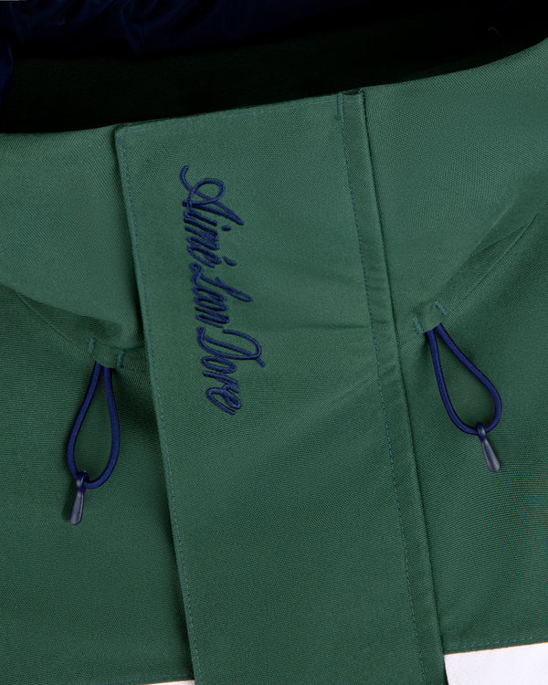 Close-up of the GORE-TEX Striped Sailing Jacket in green with blue drawstrings and Aimé Leon Dore on the flap.